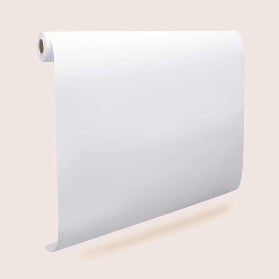 Three large Tiny Land® Easel Paper Rolls hang vertically against a light beige background, unrolling downward and casting soft shadows below.