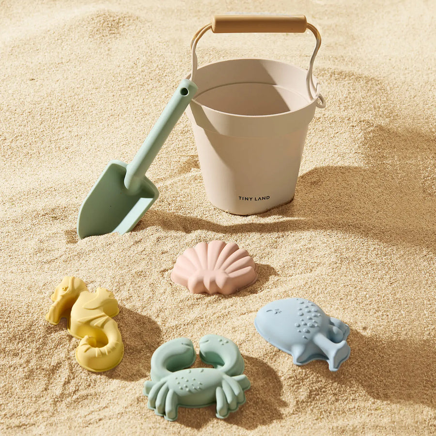 The Tiny Land® One-Stop Beach Toy & Tent Set – Pastel Yellow Stripes features a pale bucket, green shovel, and pastel molds—a seashell, seahorse, crab, and whale—ideal for sun-safe fun under the UV-protective tent.|Pastel Yellow Stripes
