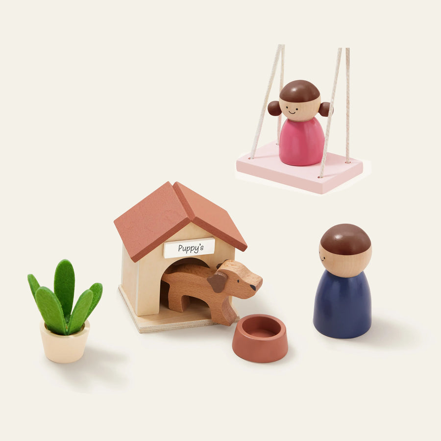 Tiny Land® Sweetwood Edge Dollhouse by Tiny Land features modern wooden toys: a brown dog in a “Puppys” house, food bowl, child on swing, standing figure, and potted plant—perfect mini family models on a light background.