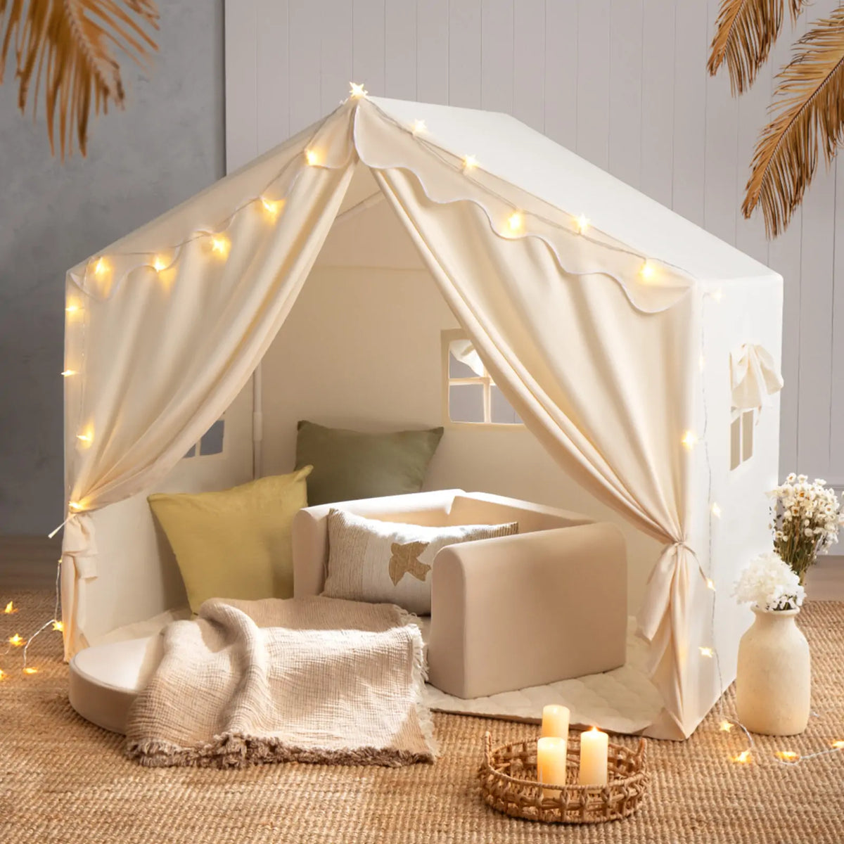 The Tiny Land® Kids Tent – Large Cozy Tent with Star Lights by Tiny Land features soft pillows, a blanket, and a small sofa on a woven rug, creating a warm, inviting atmosphere perfect for kids to play and relax.|fabric