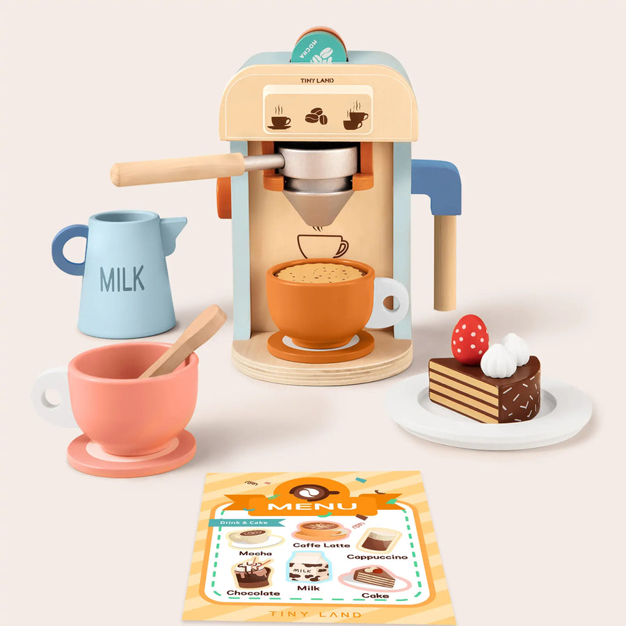 The Tiny Land® Play Kitchen Accessories – Children’s Coffee Maker Set includes a wooden coffee maker, milk jug, two cups (one with a spoon), cake slice with whipped cream and strawberry, and a menu card—perfect for kids’ kitchen play.