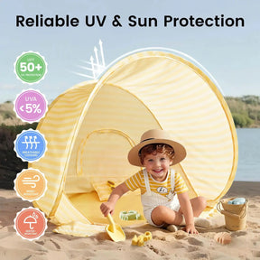 A young child with a hat plays on the sand with a yellow shovel from the Tiny Land® One-Stop Beach Toy & Tent Set, in front of its yellow-striped tent. Icons show UV50+ sun protection, breathable fabric, wind and water resistance from Tiny Land.|Pastel Yellow Stripes