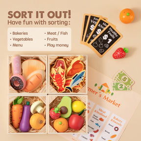A flat lay features the Tiny Land Play Food – Play Kitchen Accessories set, including wooden bread, veggies, fish, play money, and cards for sorting—next to a "SORT IT OUT!" sign for fun bakery and market pretend play.