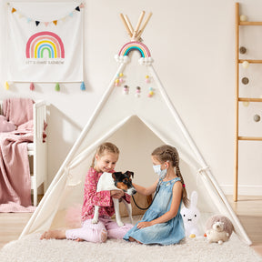 Two young girls relax indoors in the Tiny Land® Ultimate Reading Retreat: Premium Teepee & Corduroy Lounger by Tiny Land INC. One girl cradles a small dog, while the other, wearing a surgical mask, gently pets it. The white teepee, adorned with a colorful rainbow design, forms a cheerful reading nook filled with toys and plush furnishings that brighten the inviting room.|Purple