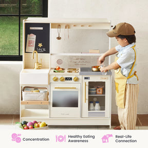 A young child wearing a cap and apron plays with the Tiny Land® BistroSwitch Play Kitchen by Tiny Land indoors. Colorful play food is visible, and icons below highlight benefits like improved concentration, healthy eating habits, and real-life connection.|Cream