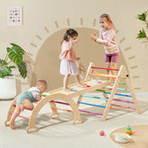 Three children enjoy the Tiny Land® Pikler Triangle 7-in-1 Montessori Climbing Set, featuring rainbow rungs, in a bright, cozy room. Two girls balance and walk on the structure while a baby climbs up the side.