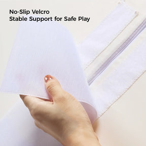 A hand peels back a strip of white Velcro on the Tiny Land® PlayNest Climbing Blocks, revealing a matching strip underneath. Text above reads: No-Slip Velcro. Stable support for safe play by Tiny Land. Ideal for gross motor development and climbing activities.