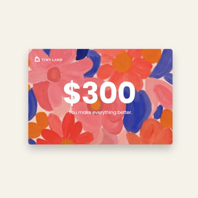 A $300 Tiny Land® Gift Card from Tiny Land, featuring a vibrant floral background in pink, red, orange, and blue. Text: "$300 You make everything better." A perfect online gift for someone special.