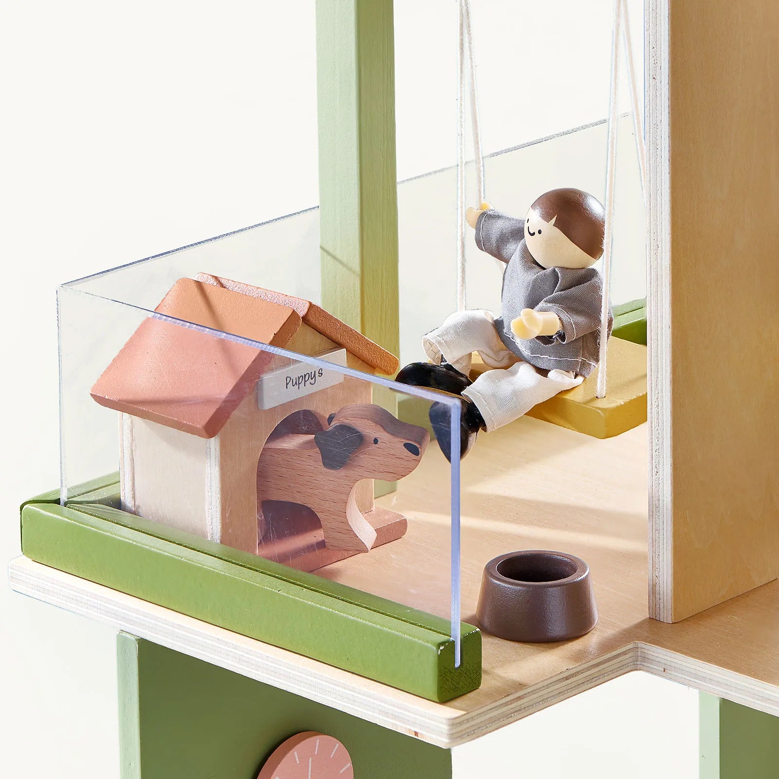 A small toy figure swings beside a miniature doghouse labeled "Puppy" with a painted dog, brown bowl, and clear fence—all part of the Tiny Land® Sweetwood Cottage Dollhouse by Tiny Land.|Green