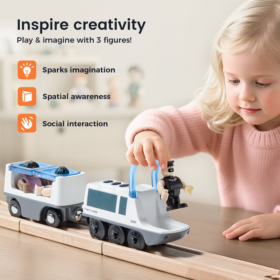 A young girl plays with the Tiny Land® Dual-Color Electric Toy Train, placing a figure inside as it moves on wooden tracks. This interactive Tiny Land set promotes creativity, imagination, spatial awareness, and social skills.|White