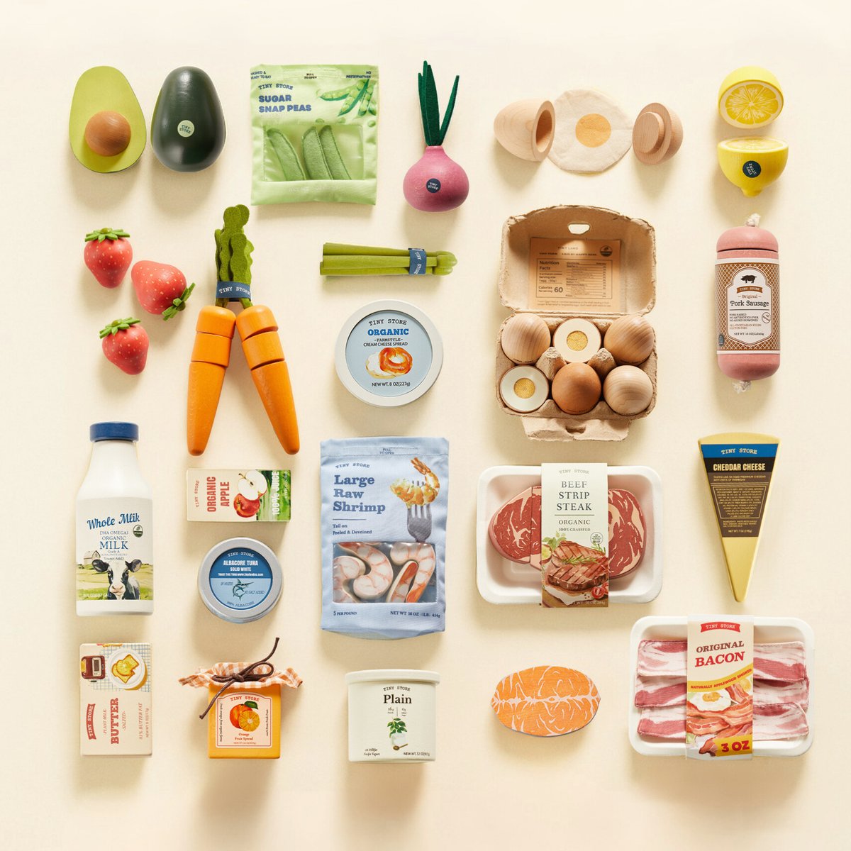 The Tiny Land® Organic Play Food Set by Target features a tidy grid of pretend eggs, milk, cheese, shrimp, steak, veggies, fruits, and condiments on a light background.