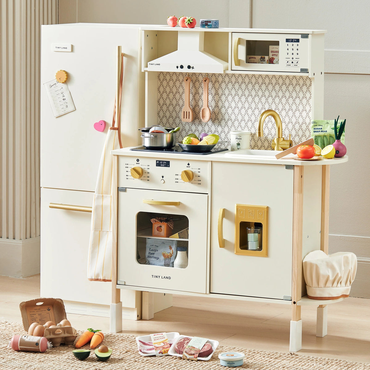 The Tiny Land® Farm-to-Table Play Set includes an interactive kitchen, storage fridge, and organic food collection. Kids can enjoy pretend play with fruits, vegetables, and grocery items from Tiny Land scattered in their own mini kitchen.