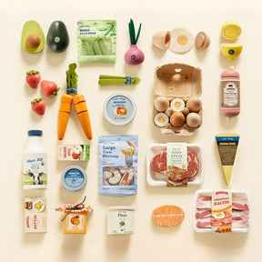 A selection of realistic vegetables, fruits, and cheese from the Tiny Land® Organic Play Food Collection by Tiny Land Play Food is neatly arranged in a grid pattern on a beige background.