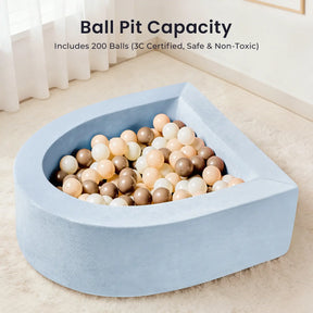 A bright room with curtains showcases the Tiny Land® PlayNest Climbing Ball Pit Set with Tunnel—a light blue, semi-circular curved foam ball pit filled with pastel and metallic-colored balls. Text above highlights the Ball Pit Capacity, noting that it includes 200 safe, non-toxic balls from Tiny Land—ideal for any indoor playground or pairing seamlessly with PlayNest climbing blocks for extra fun.|Blue