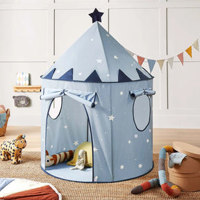 The Tiny Land® Kids Tent—a blue, castle-shaped indoor tent by Tiny Land, adorned with star and moon patterns—stands in a children’s room with plush toys, soft cushions, and a colorful pennant banner on the wall behind it.|Blue