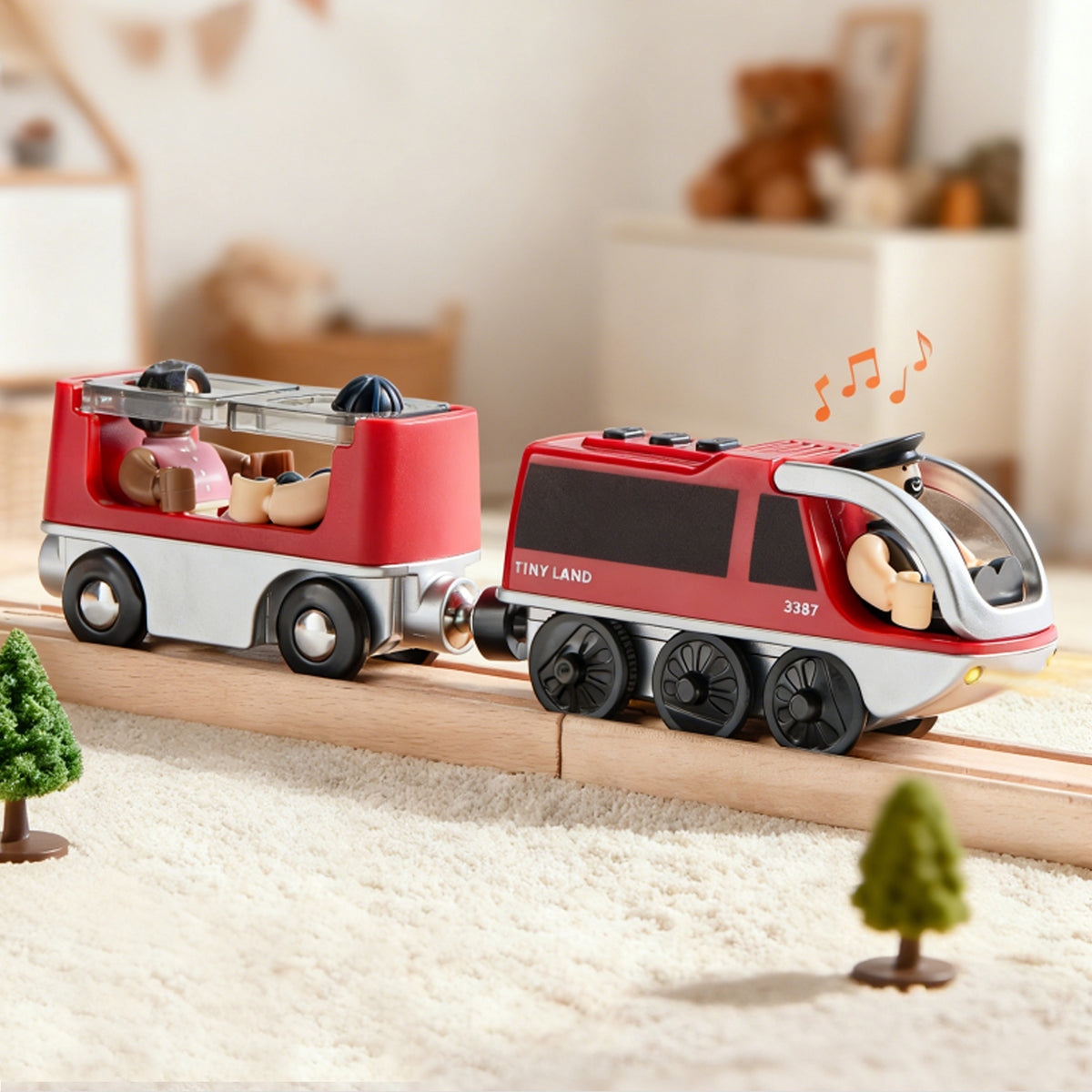 The Tiny Land® Dual-Color Electric Toy Train by Tiny Land features LED headlights and black wheels, resting on wooden tracks in a cozy playroom with toy trees and an open passenger car, perfect for interactive fun.|Red