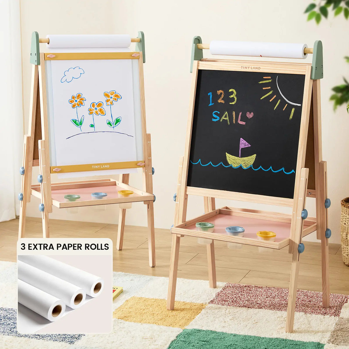 Transform any space into a creative haven with the Tiny Land® 3-in-1 Art Easel for Kids & Paper Roll Set by Tiny Land. This wooden art easel features a colorful flower-decorated whiteboard on one side, while the opposite side showcases a chalkboard illustrated with “123 SAIL,” along with playful designs of a sun, boat, and waves. The convenient inset highlights three extra paper rolls for endless artistic expression, and handy art trays keep paint cups and supplies neatly organized and within reach.