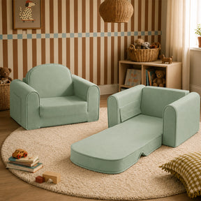 Two Tiny Land® GentleSnug Kids Sofa Chairs in light green—one unfolded into a lounger—sit on a round beige rug in a cozy playroom with striped walls, shelves, toys, books, and soft lighting.