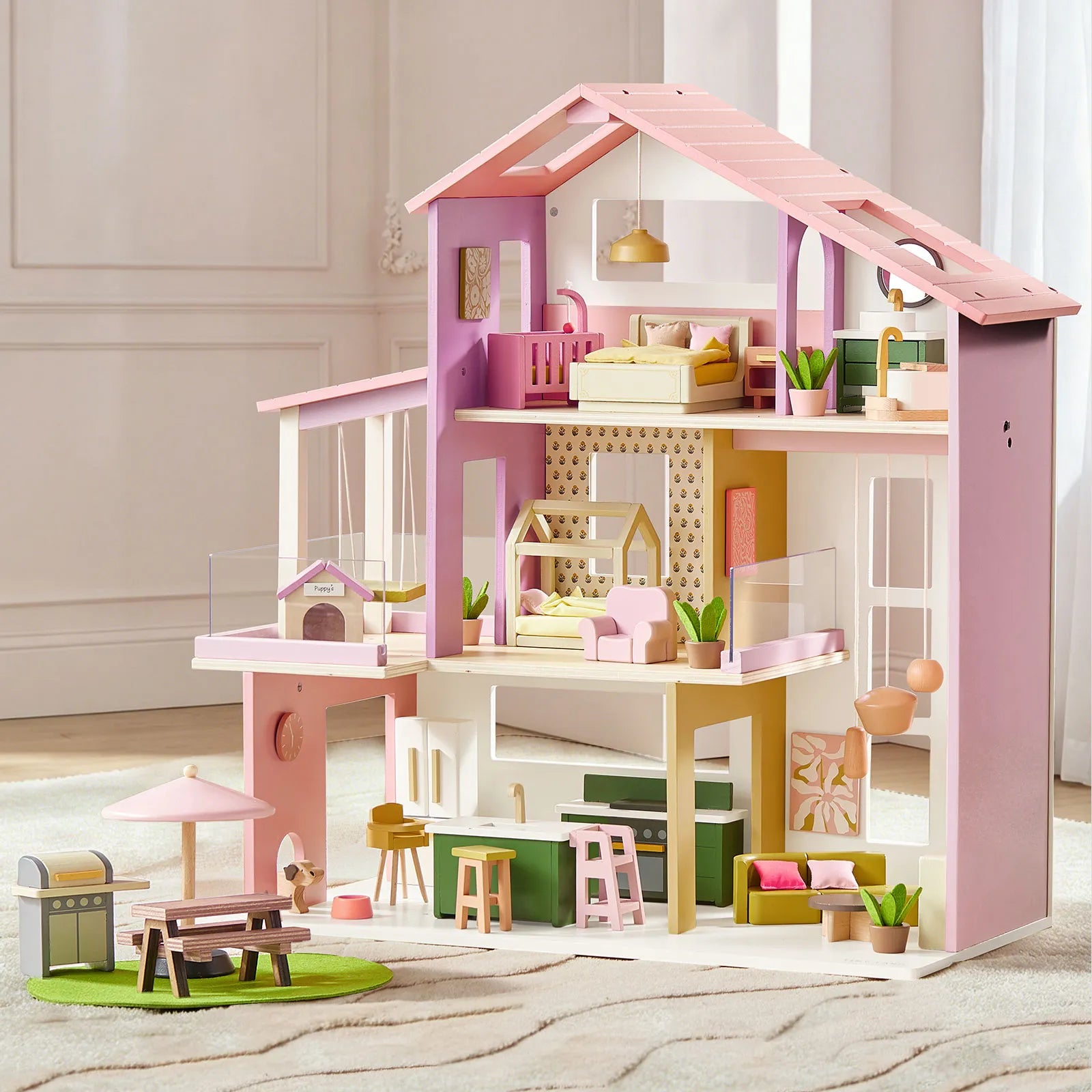 The Tiny Land® Sweetwood Cottage Dollhouse by Tiny Land features a modern pink roof, pastel furnishings, three floors, miniature furniture, plants, a patio set with umbrella, and a grill on a green rug in a sunlit room.|Pink