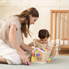 A woman and baby enjoy the Tiny Land Rainbow Baby Walker & Activity Cube Developmental Playset, sparking laughter and helping develop fine motor skills.