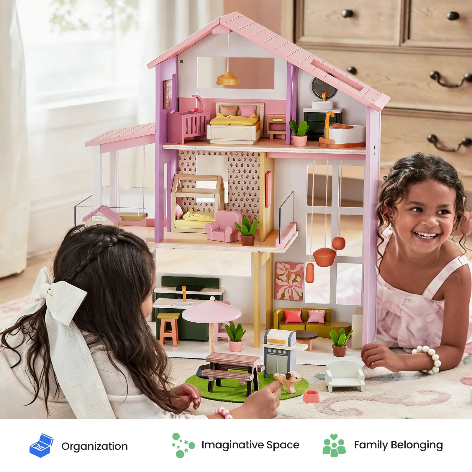 Two young girls play with the Tiny Land® Sweetwood Edge Dollhouse in Green & Pink, a vibrant wooden Montessori toy by Tiny Land. In their cozy room, they smile and interact with the furnished and decorated dollhouse, arranging the miniature furniture and dolls together.|Pink