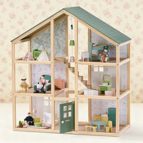 The Tiny Land® Sweetwood Evergreen Dollhouse features a green roof, six rooms with miniature furniture, floral wallpaper, and comes with Wooden Dollhouse Dolls from Tiny Land arranged throughout.