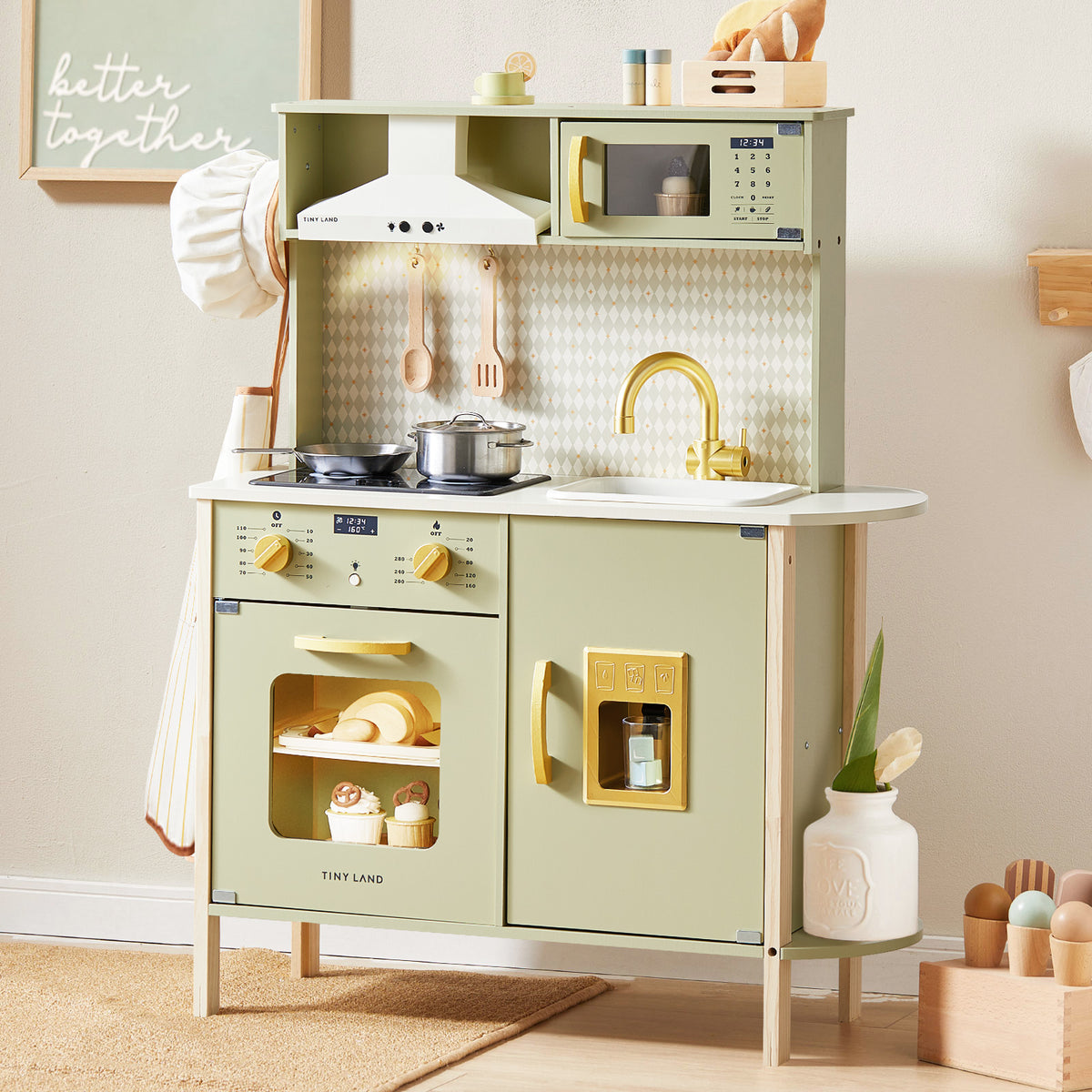 The Tiny Land® PopJoy Play Kitchen - Green by Tiny Land features utensils, a stovetop with pots, an oven with shelves, a sink, a microwave, and play food—ideal for imaginative play in any cozy playroom.