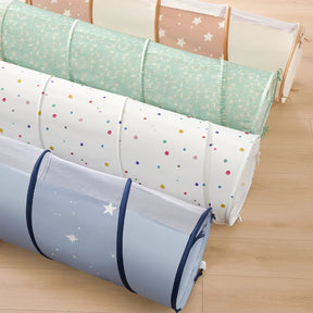 Four rolled-up Tiny Land® Adventure Play Tunnels in different pastel patterns—stars, flowers, polka dots, and solid colors—are lined up on a light wood floor. These portable crawl tunnels by Tiny Land are perfect for indoor or outdoor play adventures.
