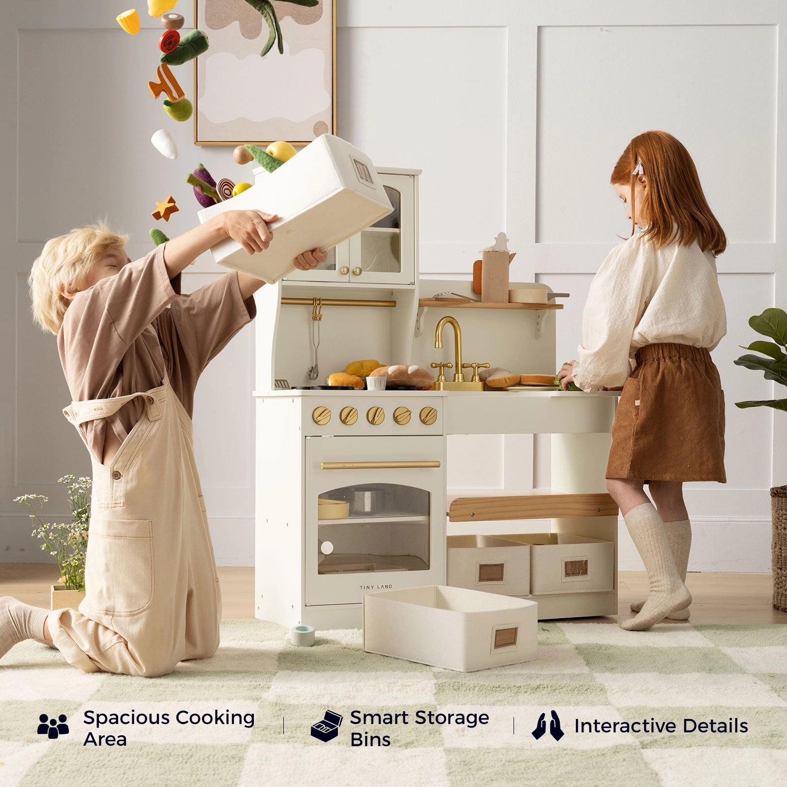 Two children play with the Tiny Land® Wooden Play Kitchen with Storage for Creative Toddlers—one pours pretend food from a bin while the other stands nearby. Icons showcase features such as a spacious cooking area, smart storage bins, included pretend cookware, and interactive design details by Tiny Land.|cream