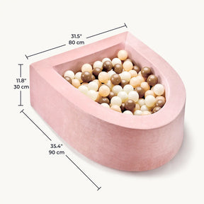 The Tiny Land® Violet PlayNest Climbing Ball Pit Set with Tunnel features a pink, velvet-textured, U-shaped foam design filled with beige, brown, and cream balls, adding a touch of elegance to any indoor playground. The dimensions—31.5 x 35.4 x 11.8 inches (80 x 90 x 30 cm)—are displayed next to the pit.|Pink