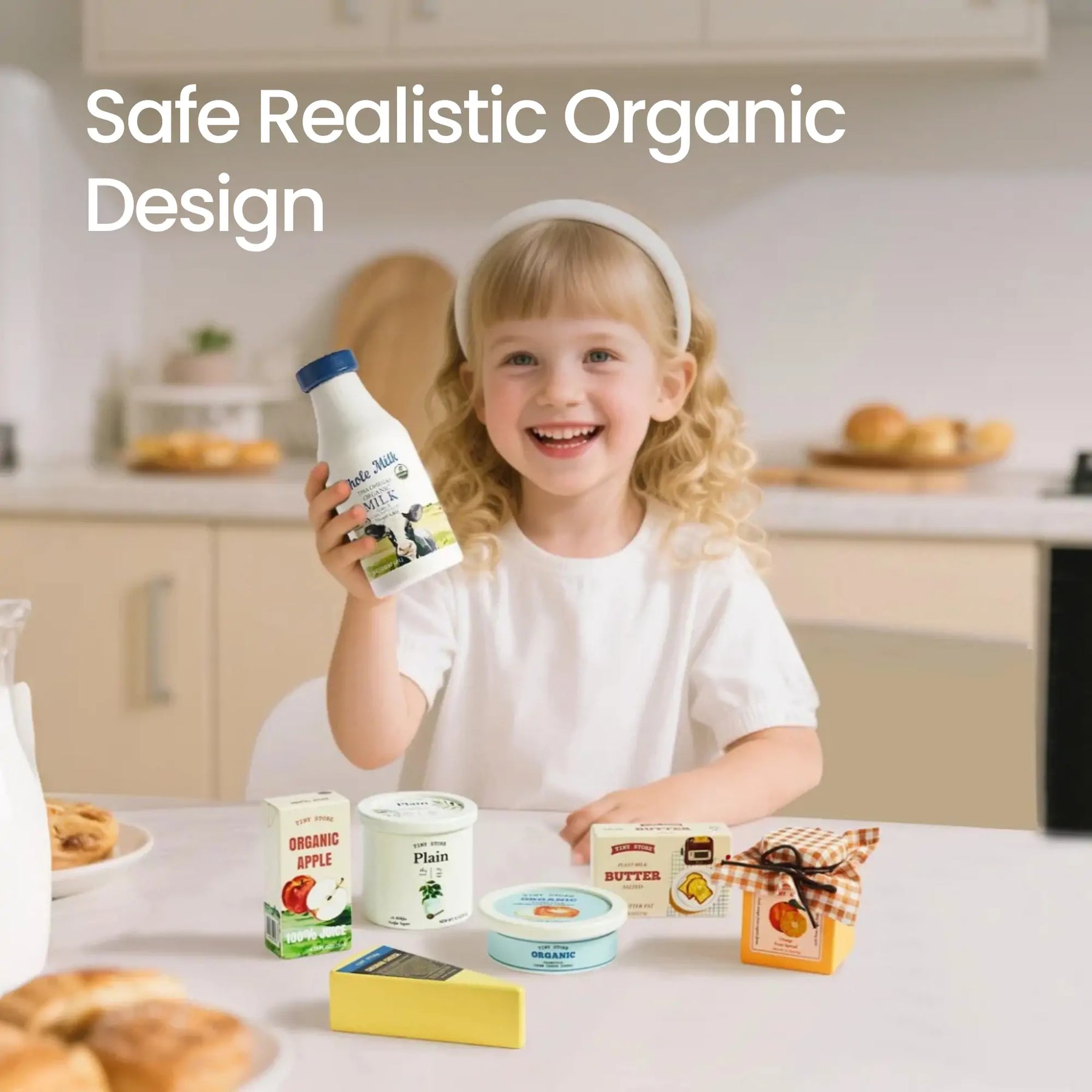 A smiling young girl with blonde hair holds a bottle and sits at a kitchen table displaying the Tiny Land® Organic Dairy Pack by Tiny Land Play Food. Text on the image reads: Safe Realistic Organic Design.