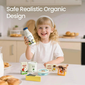 A smiling young girl with blonde hair holds a bottle and sits at a kitchen table displaying the Tiny Land® Organic Dairy Pack by Tiny Land Play Food. Text on the image reads: Safe Realistic Organic Design.