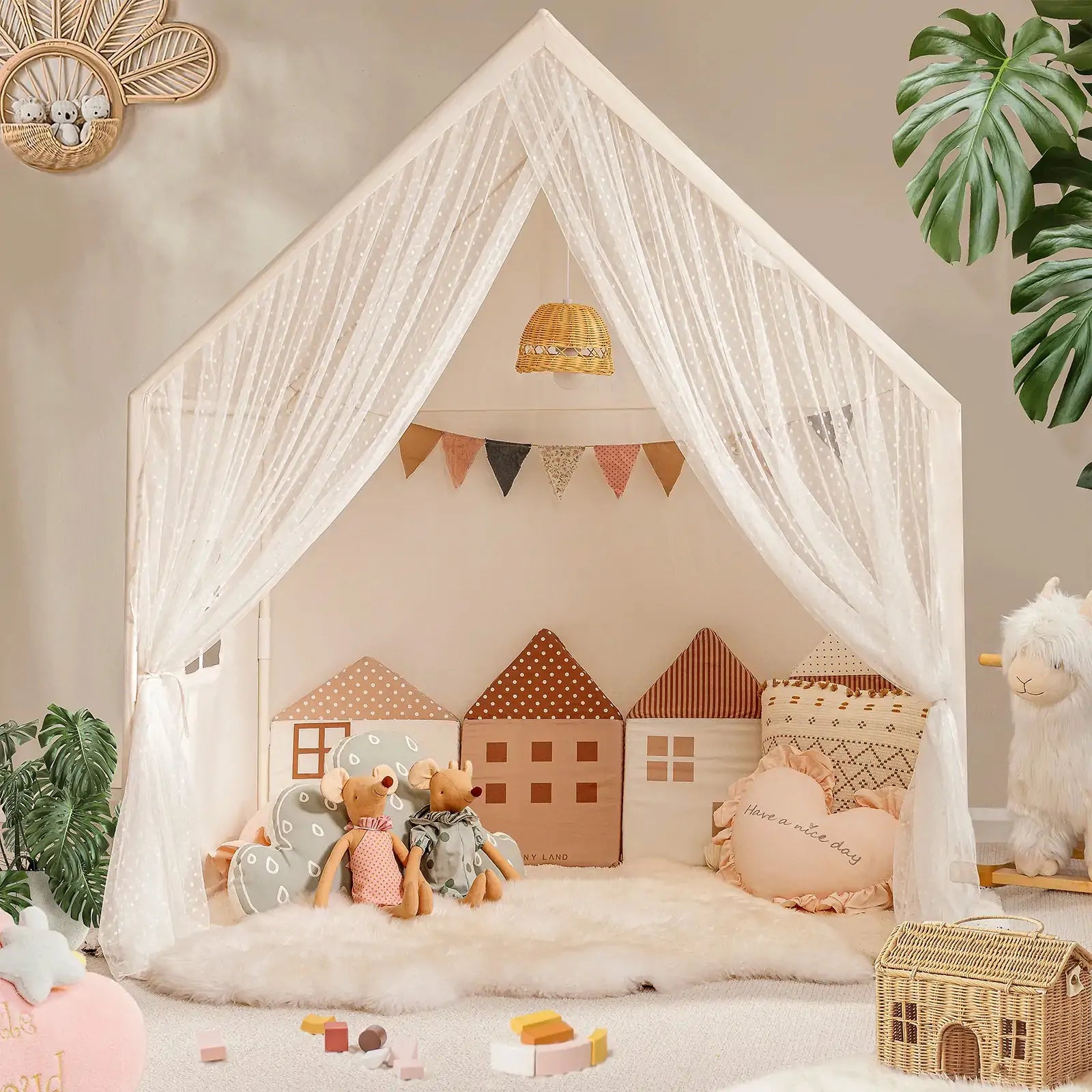 The Tiny Land® Chef’s Corner Playset features a cozy cream playhouse and kitchen set, complete with sheer white curtains, house-shaped pillows, stuffed animals, soft rugs, toys, and plants in a warmly decorated room.|mesh