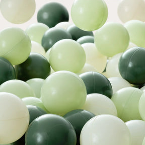 A close-up of plastic balls in white, light green, and dark green—some bouncing above the pile—in the Tiny Land® Adventure 3-in-1 Play Tunnel & Ocean Ball Set by Tiny Land.