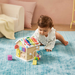 A baby crawls on the floor with the Tiny Land Rainbow Baby Walker & Activity Cube Developmental Playset, reaching out to explore and build fine motor skills.