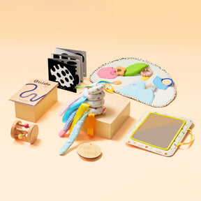 Tiny Land® Montessori Toys for Newborns (0–3 Months) by Tiny Land—a pastel set with soft cloth book, textured mat, wooden rattle, fabric loop ring, mirror, and guide—ideal for tummy time and sensory play on a beige background.