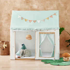 The Tiny Land® Sweet Woodland Kids Play Tent by Tiny Land features a pastel house-shaped design with a triangular roof and bunting. It includes plush toys, cushions, and a play mat, with a woven basket, lamp, plant, and toy house nearby.|green