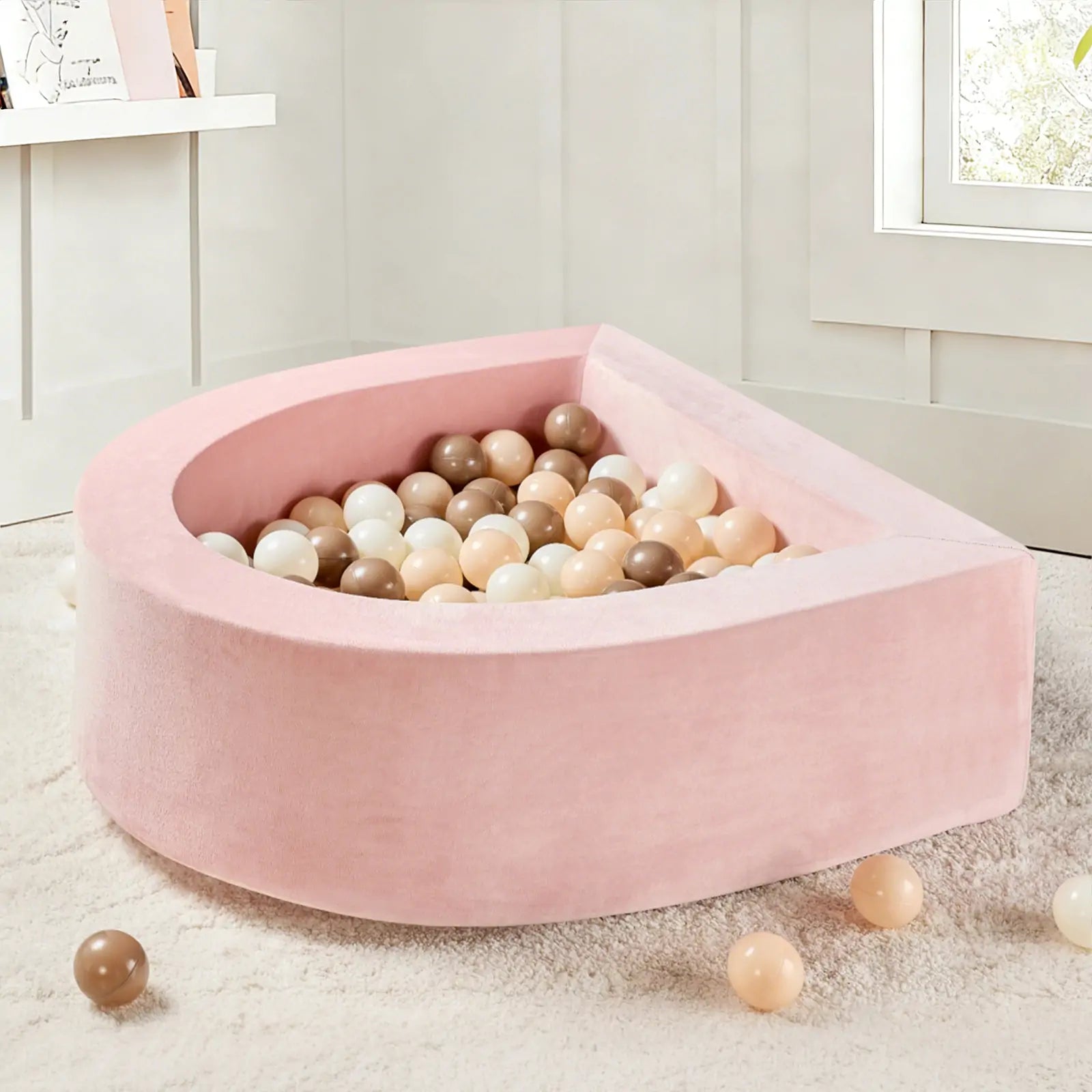 The Tiny Land® Violet PlayNest Climbing Ball Pit Set with Tunnel, filled with pastel-colored balls, rests on a soft cream-colored rug in a bright, cozy room.|Pink