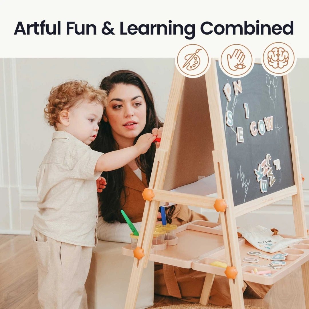 An adult and child use the Tiny Land® Caramel Magnitales Easel for Kids with magnets and chalkboard, engaging in a fun learning activity. Text above reads: Artful Fun & Learning Combined.