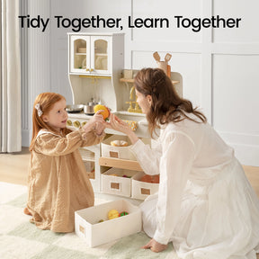 A woman and a young girl clean up toy food and pretend cookware in the Tiny Land® Wooden Play Kitchen with Storage for Creative Toddlers. Large text reads, Tidy Together, Learn Together.|cream