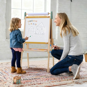 A young child and an adult smile together while drawing houses and “Dream Land” on the whiteboard of the Tiny Land® 3-in-1 Art Easel for Kids - Morandi by Tiny Land in a bright, cozy room.|green