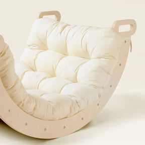 Inspired by the Tiny Land® 7-in-1 Montessori Climbing Set with Play Pad, this modern rocking chair by Tiny Land features a light wooden frame, plush cream tufted cushion, and cut-out handles on both ends of the frame.