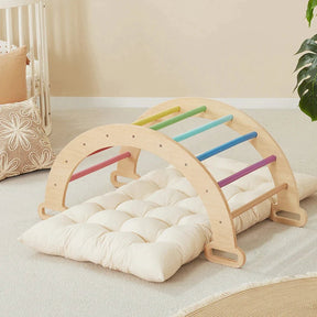 The Tiny Land Adventure Playground Gift Set—featuring a climbing set with pad, balance beam, and stepping stones—sits in a cozy, carpeted room with soft decor and a potted plant close by.