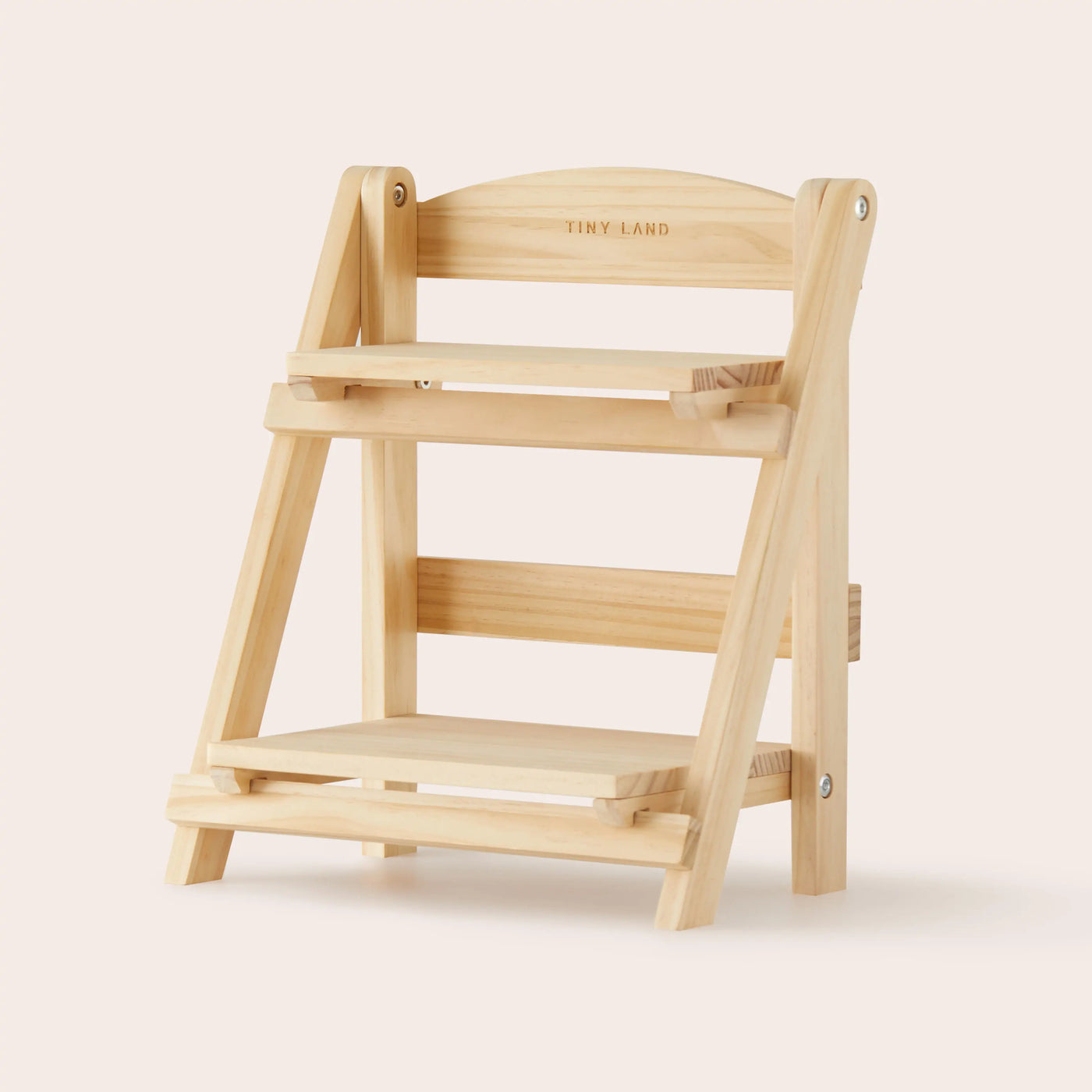 A compact, light wood two-tier display shelf with "Tiny Land" engraved on top, featuring an A-frame and angled shelves—ideal for showcasing premium toys or storing your Tiny Land® Mystery Surprise Box against a beige backdrop.