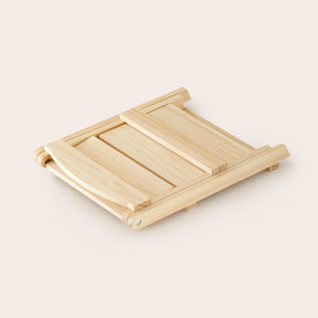 The Tiny Land® Play Kitchen Accessories – Play Kitchen Food Storage features a versatile wooden rack, crafted by Tiny Land, shown closed and lying flat on a cream background with visible smooth wood grains.