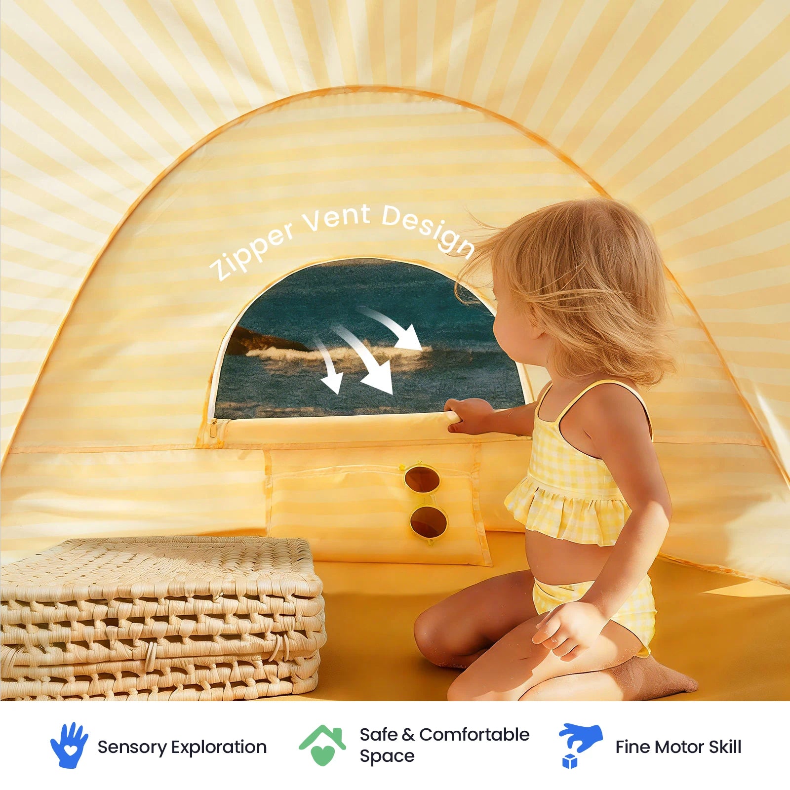 A toddler in a yellow swimsuit sits inside the Tiny Land® One-Stop Beach Toy & Tent Set, which features UV protection and a zippered vent, gazing out at the ocean. Icons below highlight sensory exploration, safety, and fine motor skill benefits—making this Tiny Land set perfect to pair with a sand play kit.|Pastel Yellow Stripes