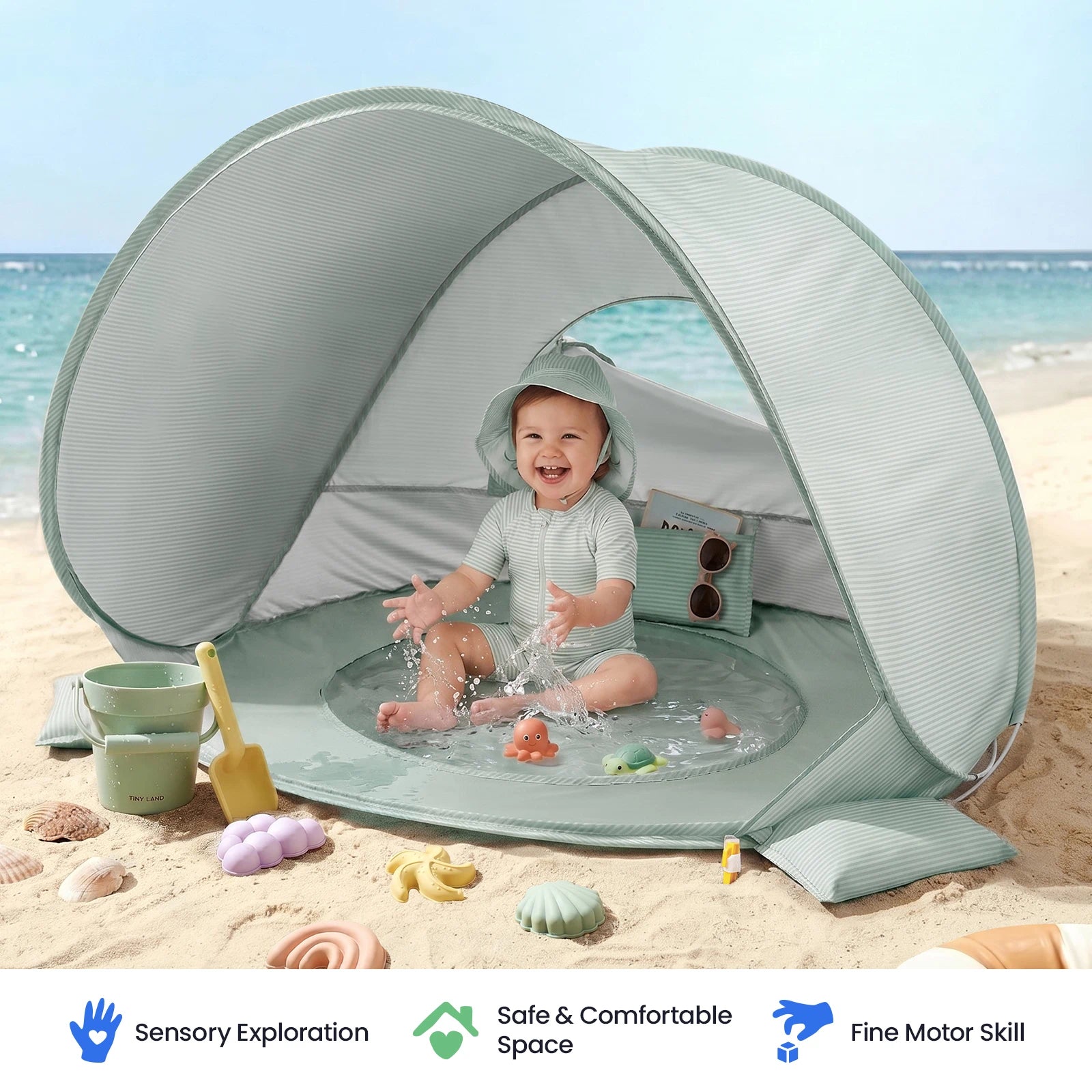 A baby enjoys playing with water and the colorful sand toy set from the Tiny Land® 4-in-1 Tent: Beach Tent & Sand Toy Set on the sand, surrounded by sand toys and seashells beneath the striped toddler tent. The ocean and sky provide a beautiful backdrop, while icons and text below showcase key benefits for families from Tiny Land.|Green