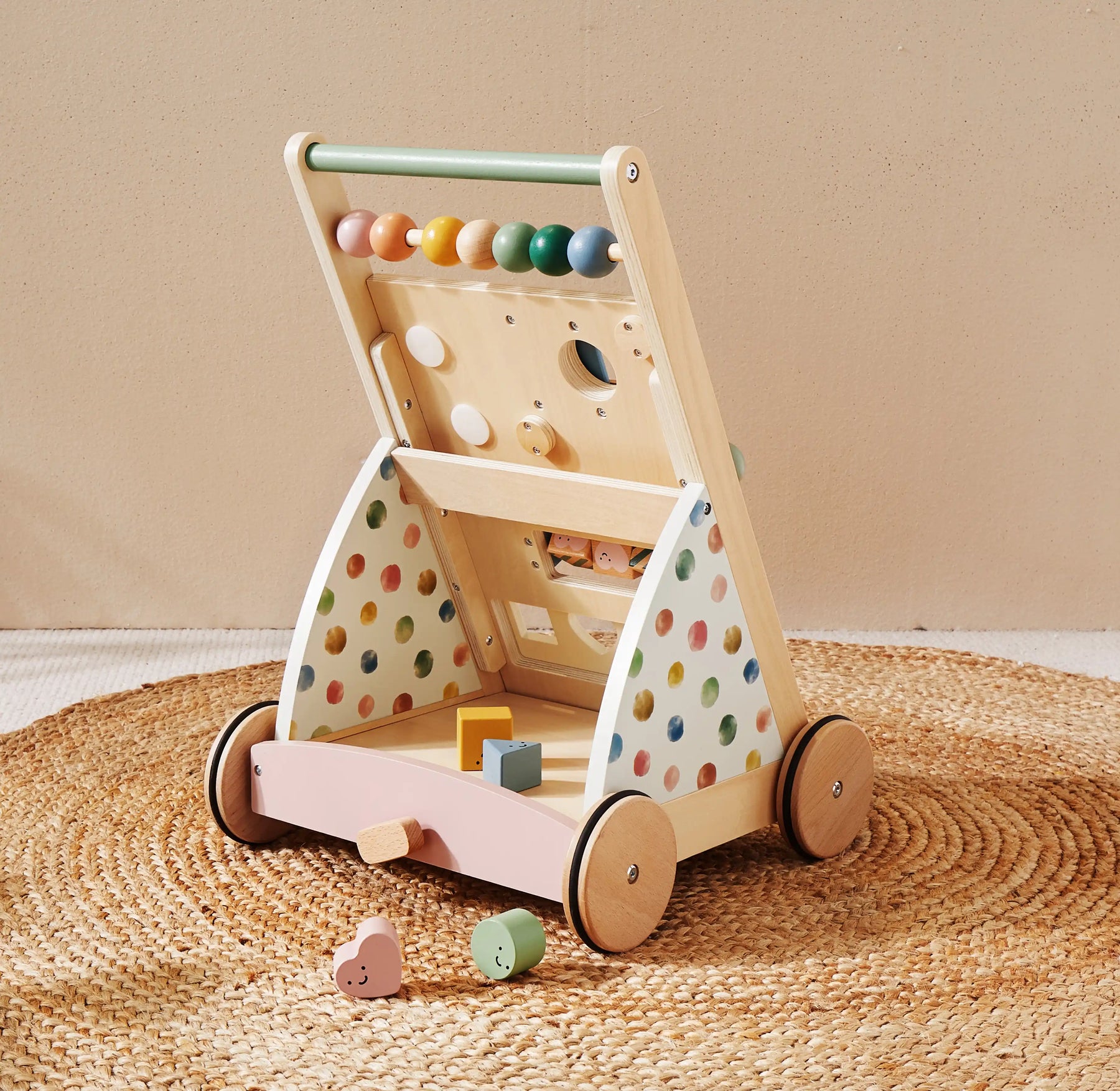 The Tiny Land® Versatile Natural Wooden Baby Walker by Tiny Land features colorful beads, polka dot sides, and a tray of geometric blocks, displayed on a woven round rug against a neutral background|Morandi