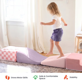 A young child balances while walking on the soft, colorful pieces of the Tiny Land® Violet PlayNest Climbing Ball Pit Set with Tunnel in a sunlit room, creating an inviting indoor playground. Icons below highlight gross motor skill development, a safe and comfortable space, and stability—signature features from Tiny Land.|Pink
