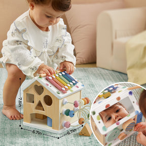 A baby in a white outfit plays with the Tiny Land Cozy Learning Playset—Playmat + Activity Cube, featuring colorful xylophone bars, beads, shape cutouts, and a mirror for self-discovery. An inset displays measurements on this engaging developmental toy.